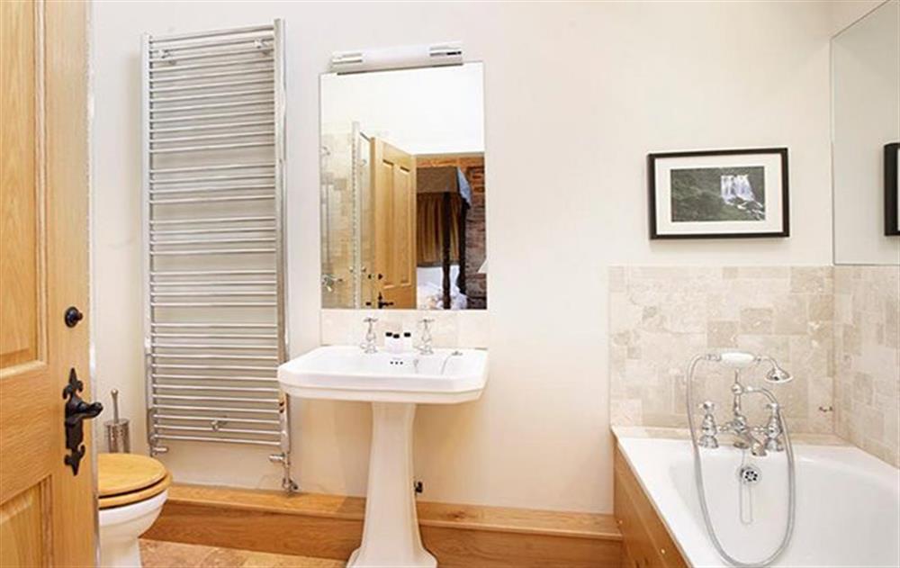 En-suite bathroom with separate shower to double bedroom with 5’ four poster bed at Wythburn Cottage, Nr Greystoke