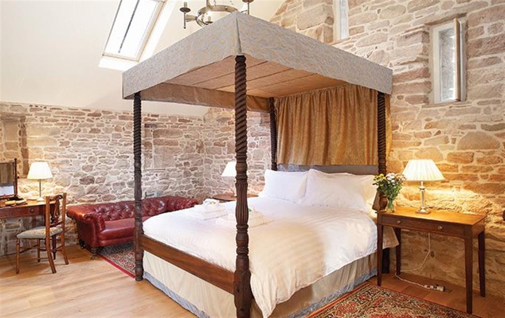 Master bedroom with 5’ four poster bed with en-suite bathroom with a separate shower at Wythburn Cottage, Nr Greystoke