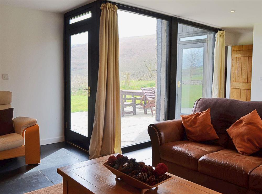 Fabulous leather sofas and easy access from the living room to the patio at Y Stabl in Bethlehem, Carmarthenshire