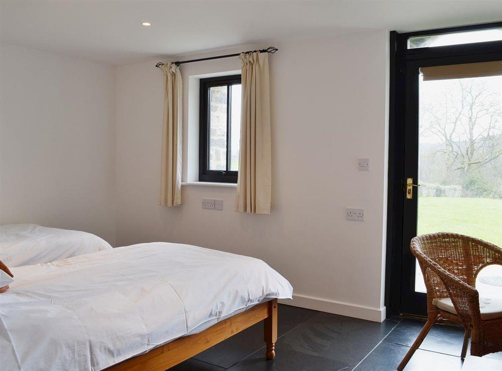 Twin bedroom with slate floor and garden access at Y Stabl in Bethlehem, Carmarthenshire