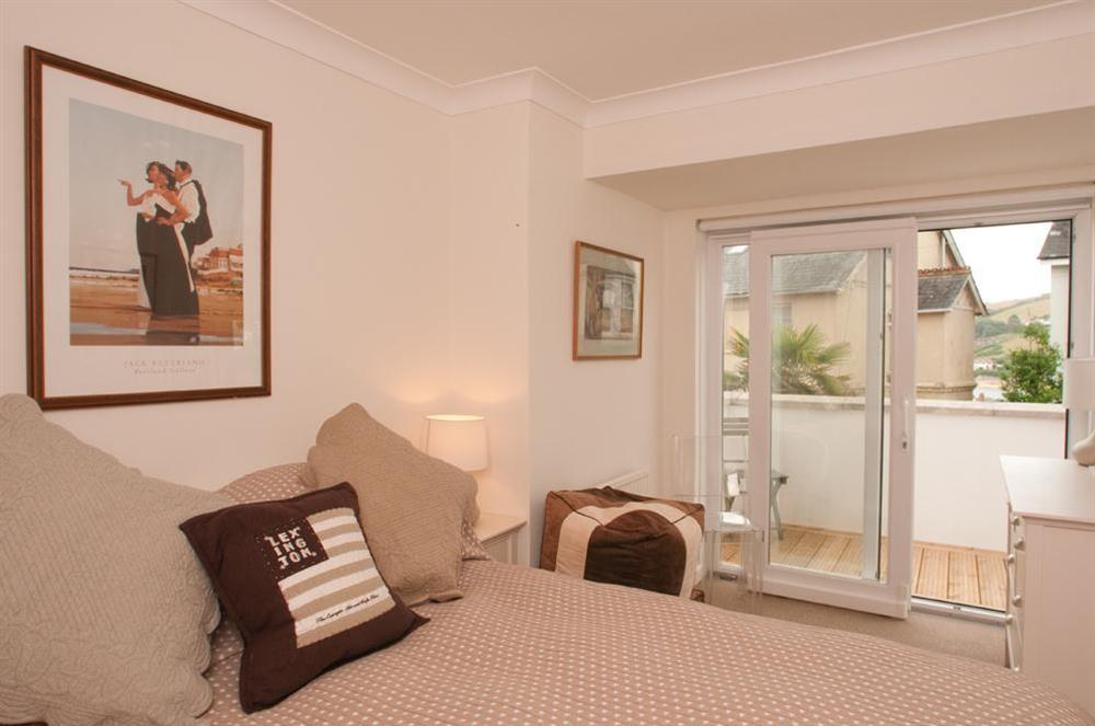 Ground floor king-size bedroom with doors leading to decked patio at Yardarm in 42 Devon Road, Salcombe