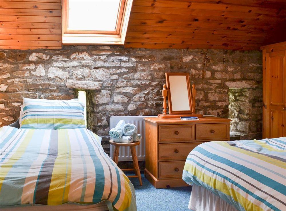 Twin bedded room with exposed stone wall