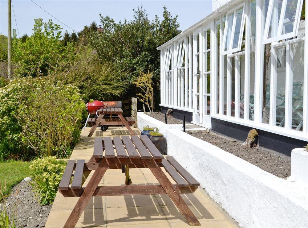 Paved patio/terrace with BBQ area and ‘picnic style’ outdoor furniture at Yawl House in Uplyme, near Lyme Regis, Devon