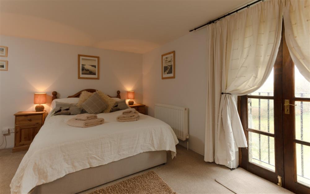 The double bedroom with Juliet balcony which overlooks the valley at Yeomans Cottage in Salcombe