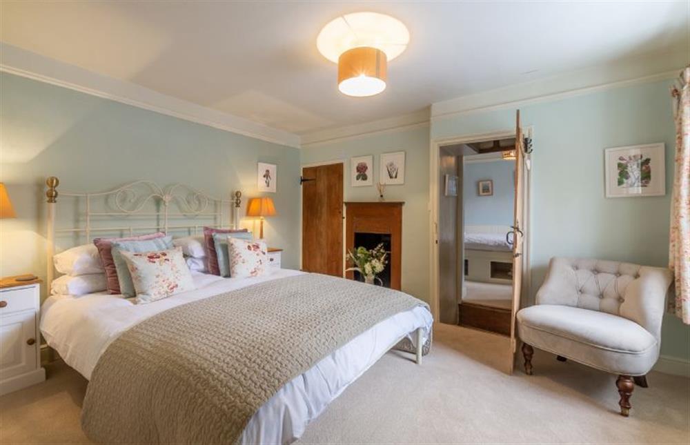First floor:  Master bedroom with decorative fireplace at Yew Tree Cottage, Blakeney near Holt