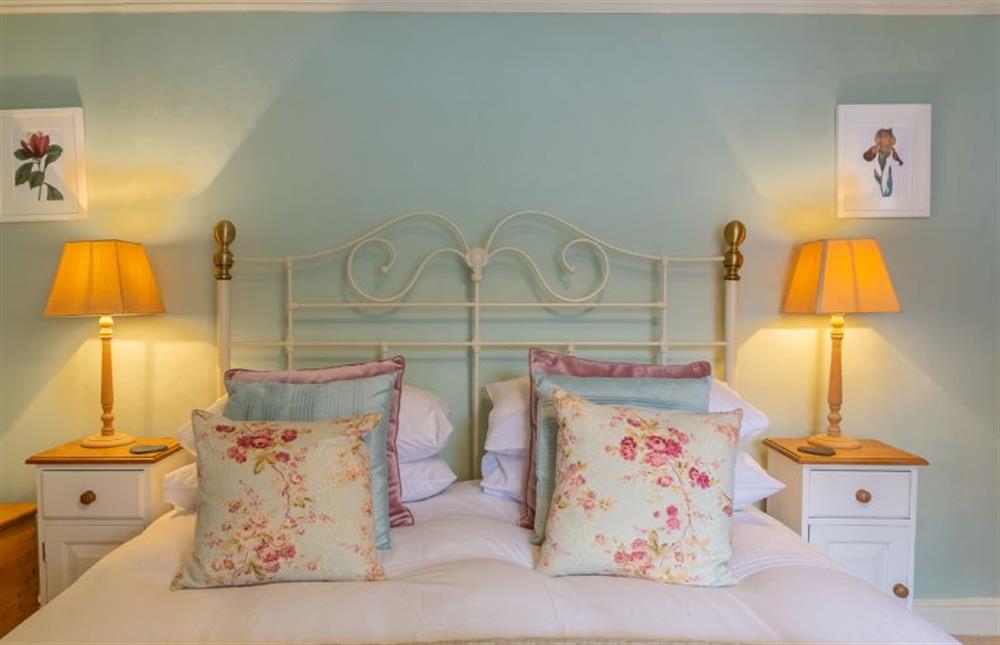 First floor:  Master bedroom with king size bed and feature headboard at Yew Tree Cottage, Blakeney near Holt