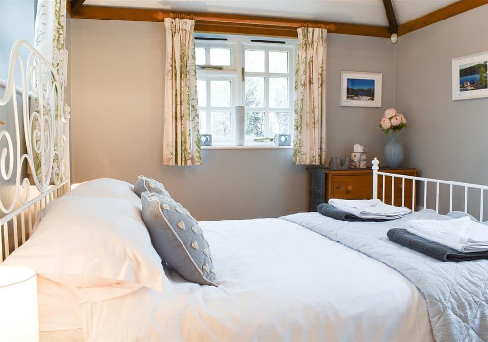 Comfortable bedroom with antique style bed at Yew Tree Cottage in Farnham, near Blandford Forum, Dorset