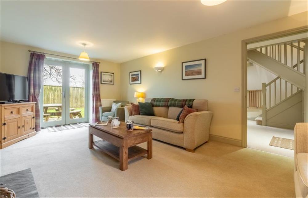 Ground floor: The sitting room has doors opening into the garden at York Cottage, Docking near Kings Lynn