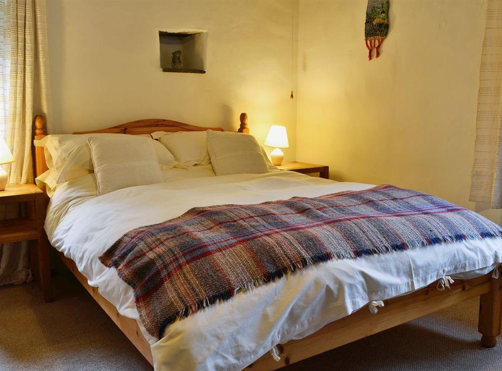 Bedroom with double bed and bunk beds at Yr Hen Stabl in Arthog, near Dolgellau, Gwynedd