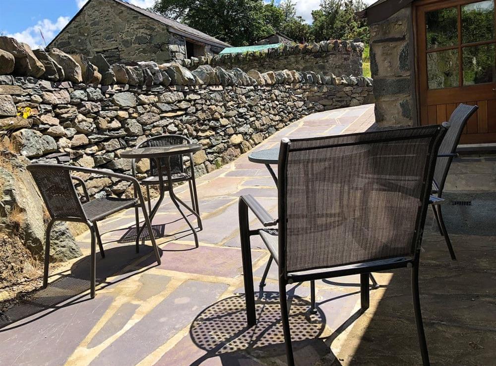 Paved patio with table and chairs at Ysgubor in Tregarth, near Bangor, Gwynedd